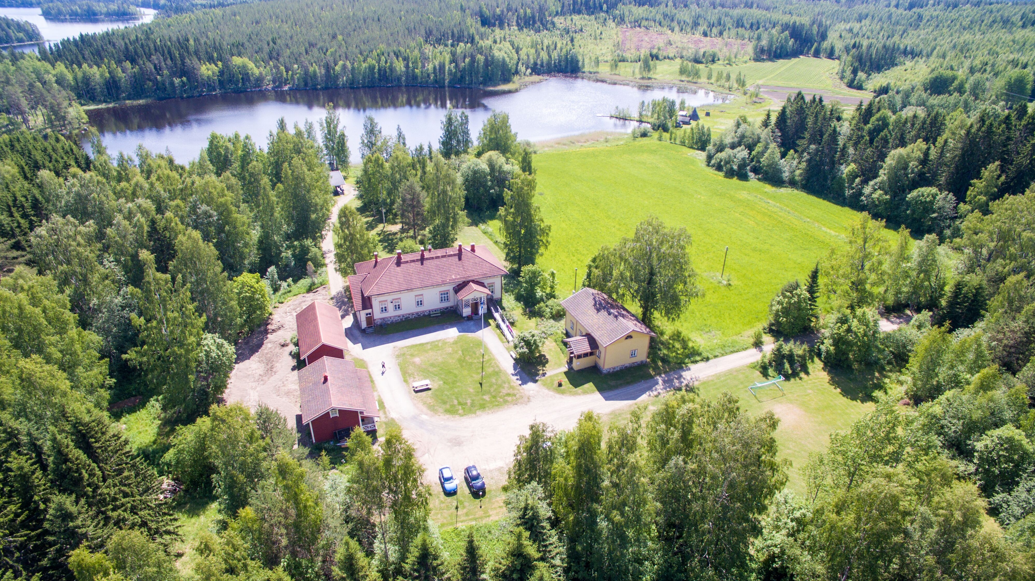 Kesäinen kuva Harjulan leirikeskuksesta, jossa näkyvät kaikki rakennukset
