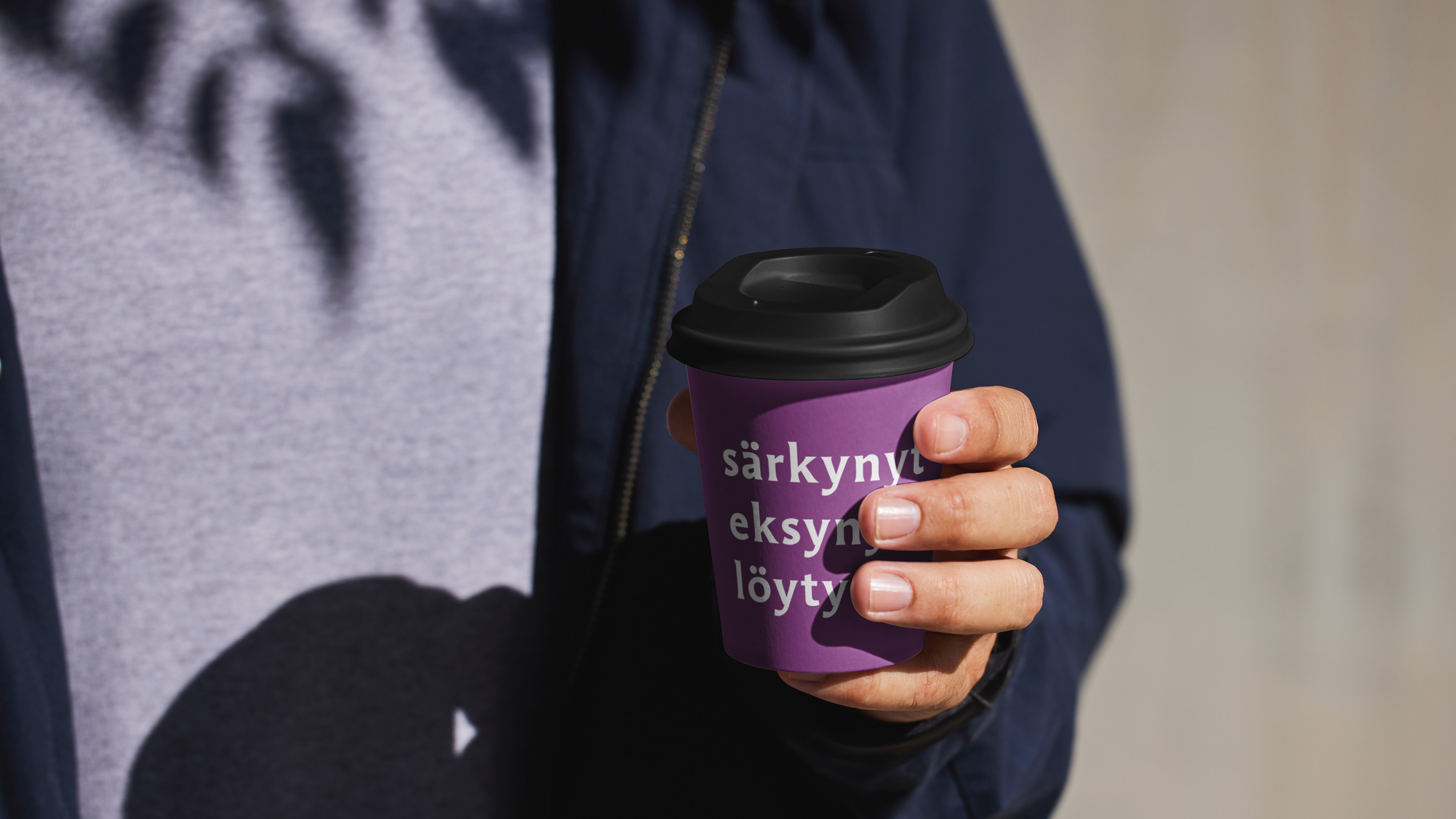 kädessä on violetti kahvimuki jossa on teksti särkynyt eksynyt löytynyt